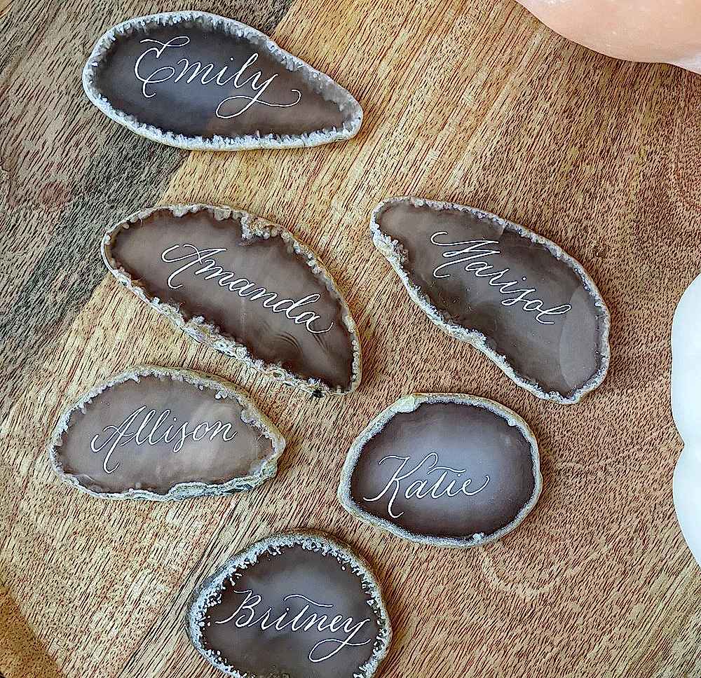 Close-up of engraved champagne flutes from a private party, featuring live calligraphy-style engraving on metal bases